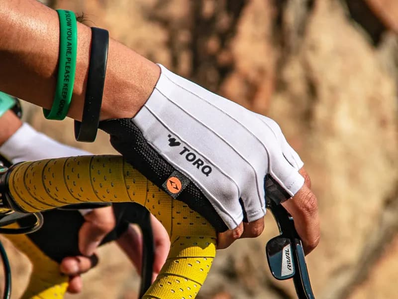 Rider's hand wearing a Torq cycling glove on the handlebar